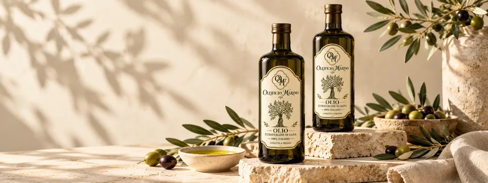 Due bottiglie di olio extravergine Oleificio Marino su gradini di pietra, con rami d’ulivo